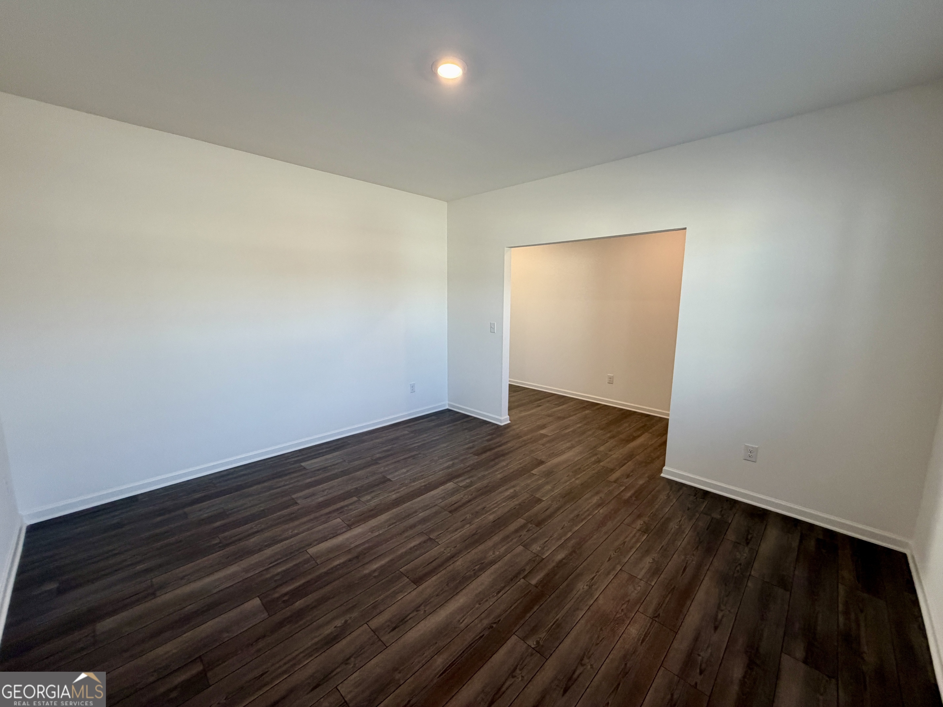 788 Gelderland Drive Hampton, GA 30228 - Photo 5 of 27 a view of an empty room with wooden floor and a window