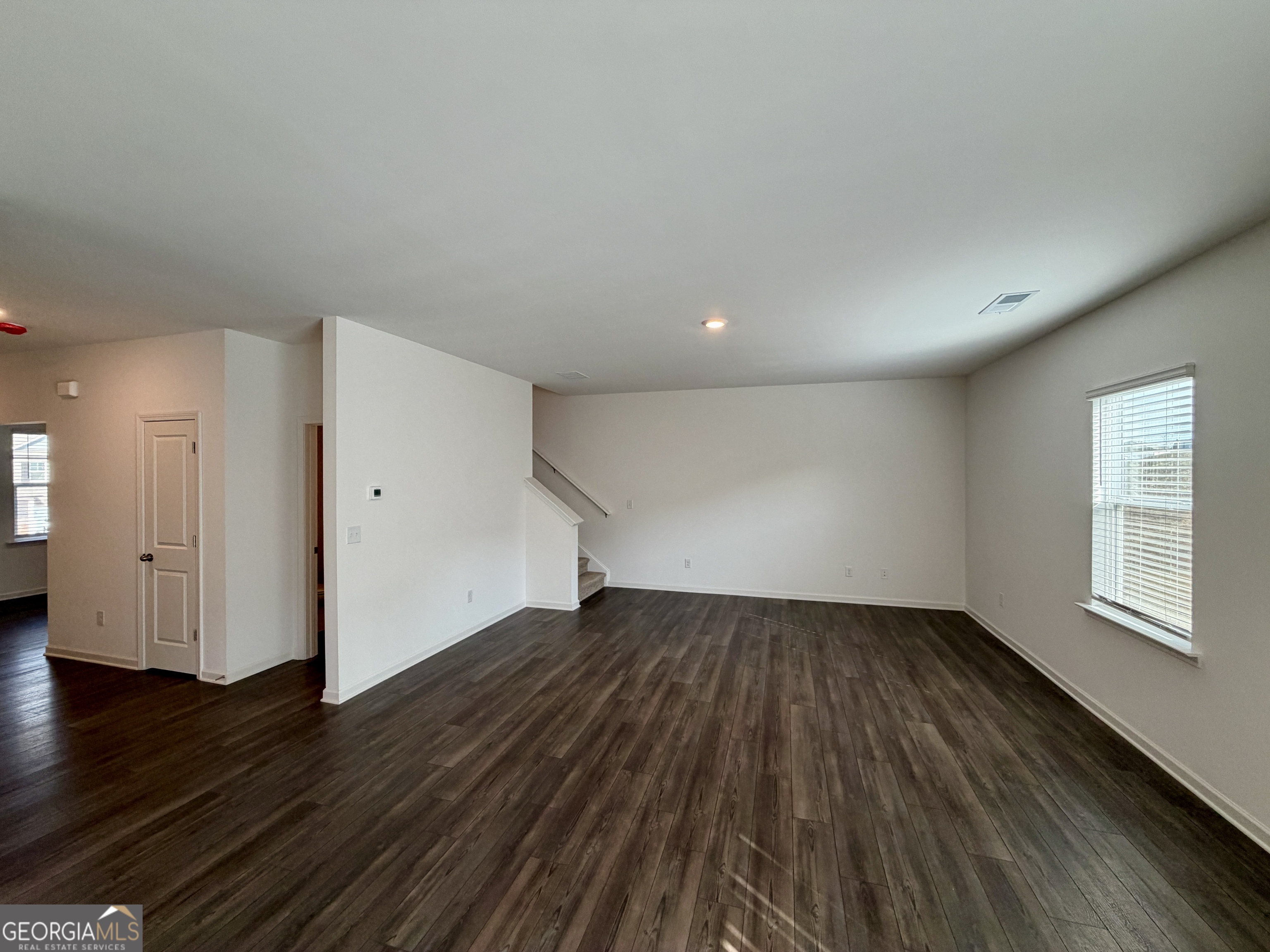 788 Gelderland Drive Hampton, GA 30228 - Photo 7 of 27 a view of an empty room with wooden floor and a window