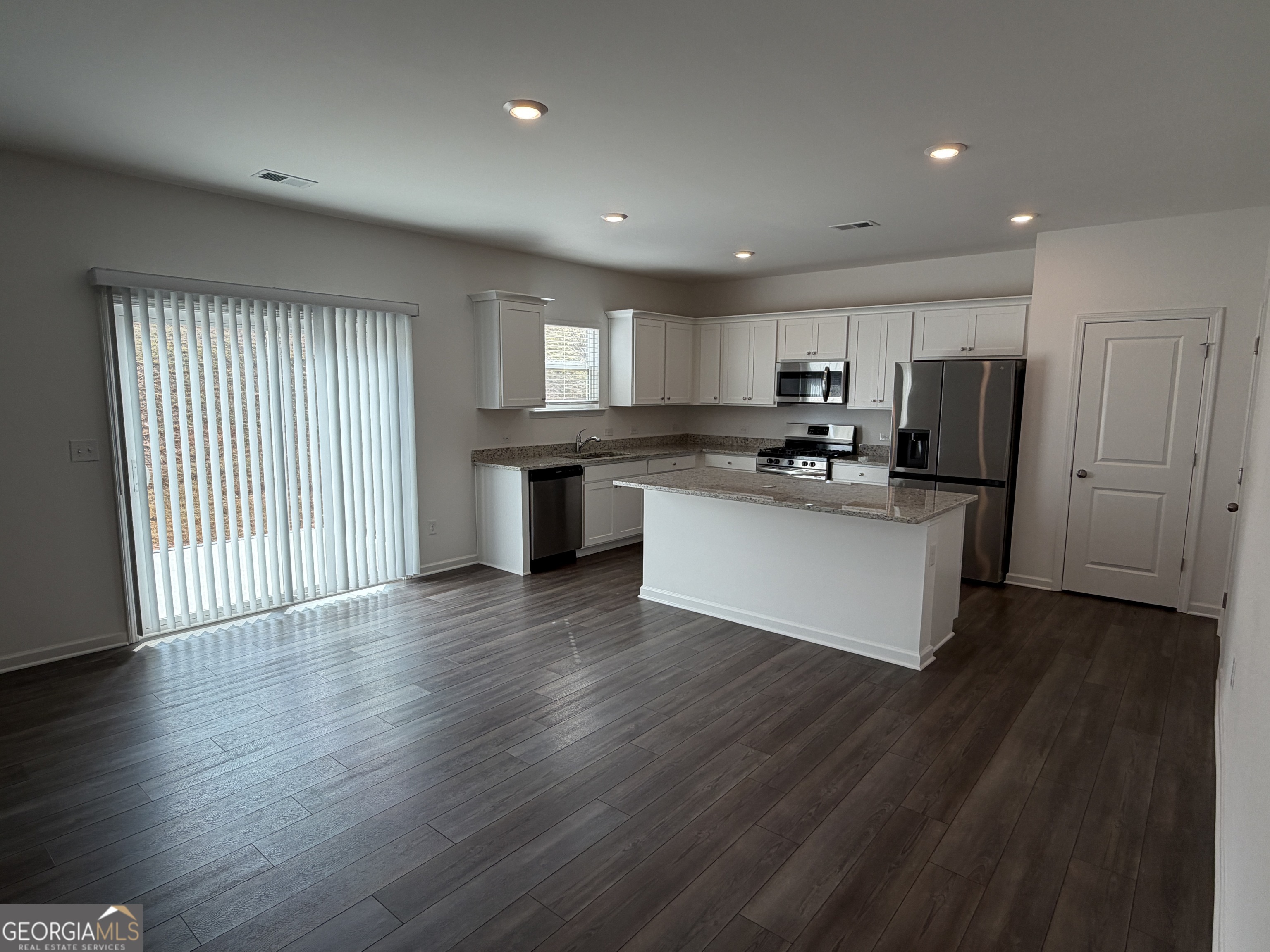 788 Gelderland Drive Hampton, GA 30228 - Photo 8 of 27 a kitchen with stainless steel appliances granite countertop a refrigerator a sink dishwasher a stove and a microwave oven on wooden floor