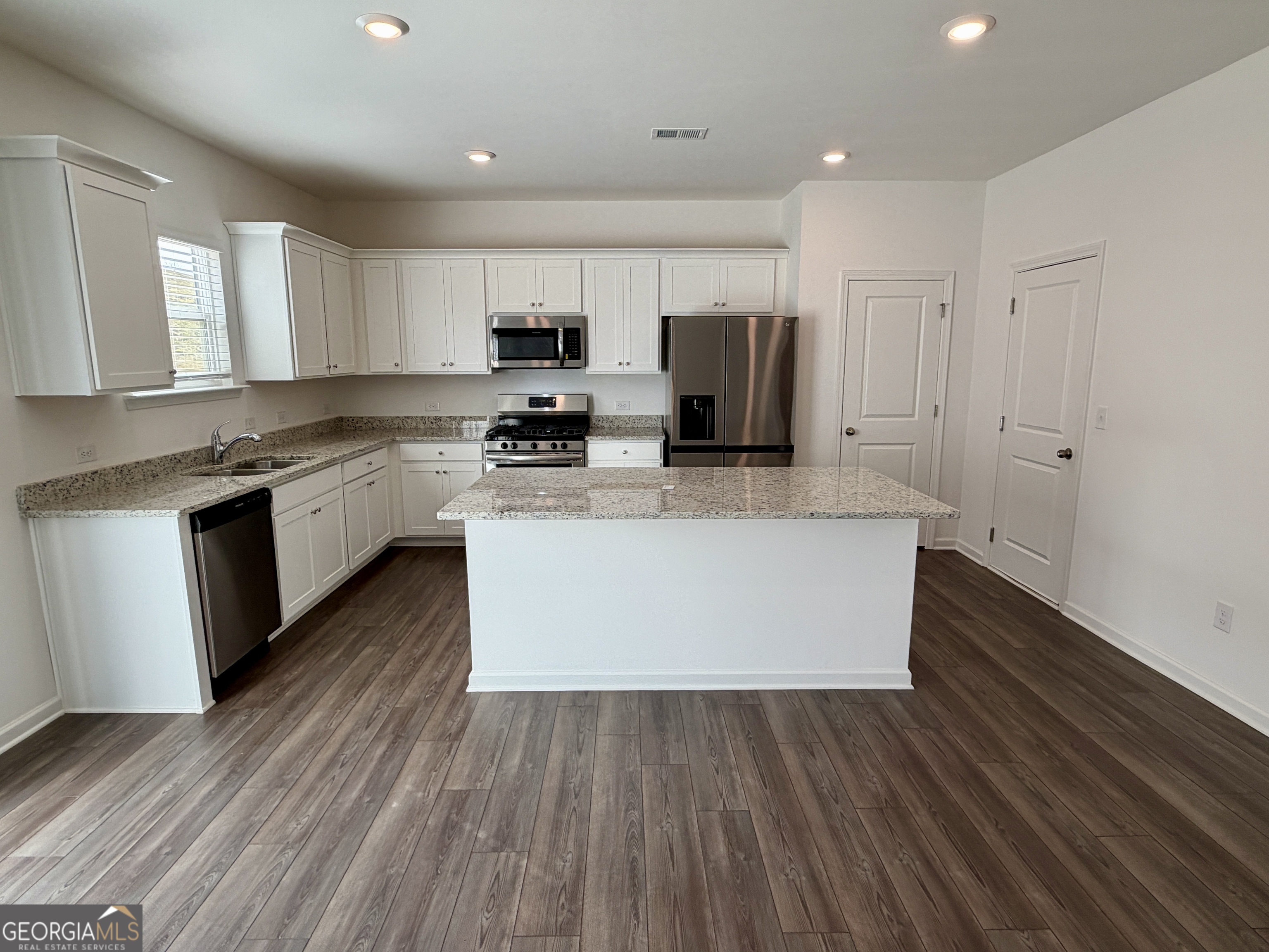 788 Gelderland Drive Hampton, GA 30228 - Photo 9 of 27 a large kitchen with stainless steel appliances granite countertop a stove a sink dishwasher and a refrigerator with wooden floor
