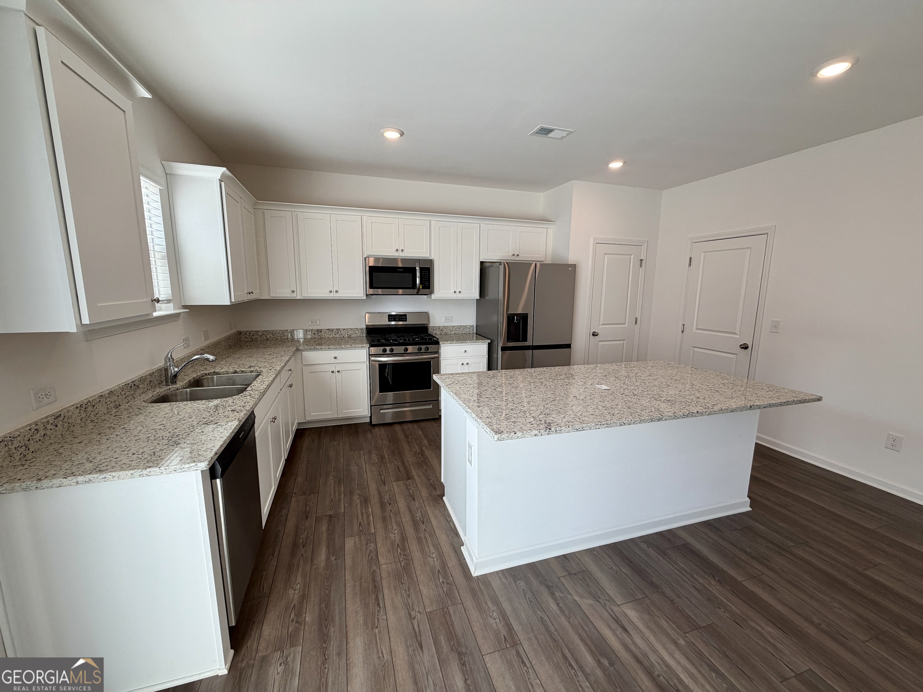 788 Gelderland Drive Hampton, GA 30228 - Photo 10 of 27 a kitchen with kitchen island granite countertop a sink cabinets and wooden floor