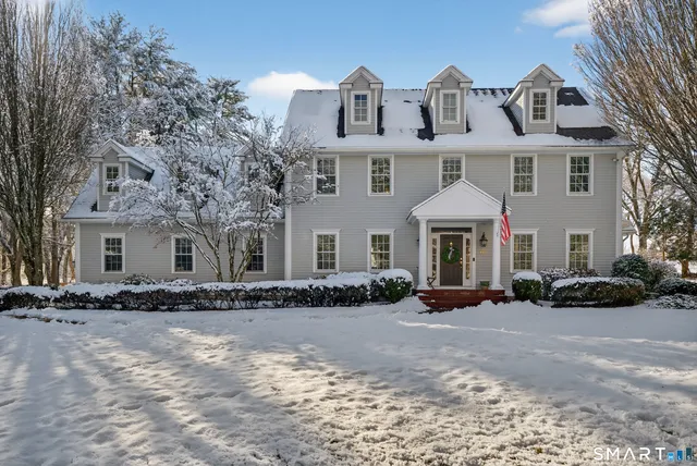 a front view of a house with a yard covered in snow