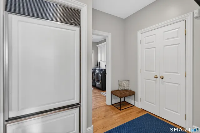 a view of a hallway with wooden floor and a door