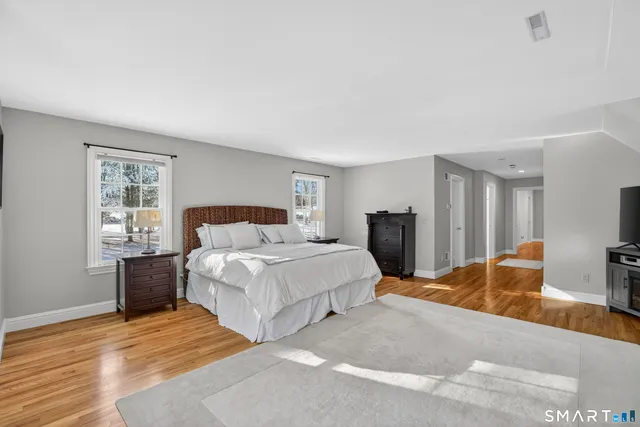 a bedroom with a large bed and wooden floor