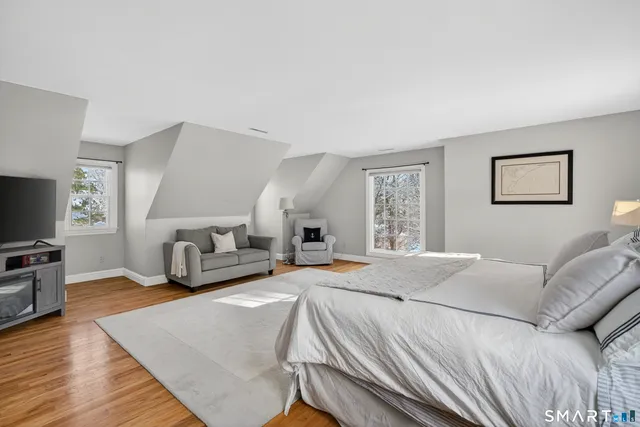 a spacious bedroom with a bed and a flat screen television