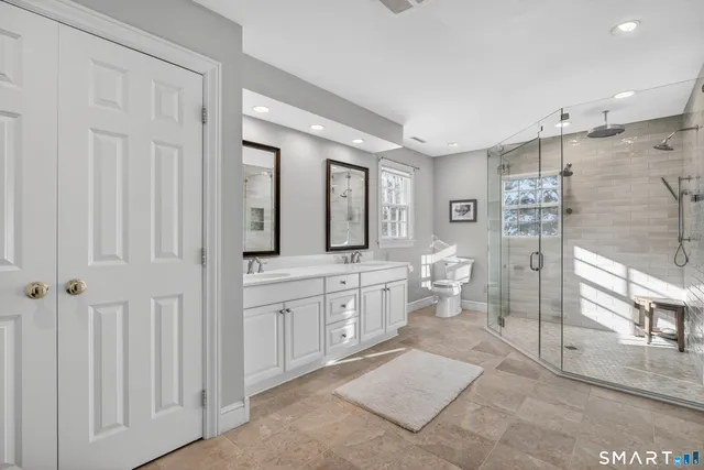 a spacious bathroom with double vanity and a shower