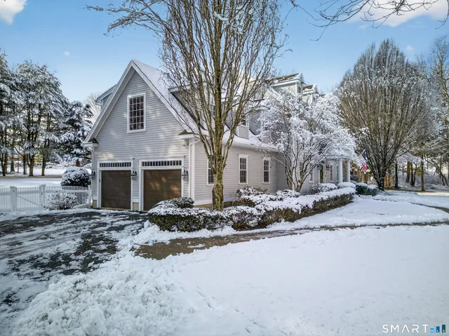 a front view of house with yard covered in snow