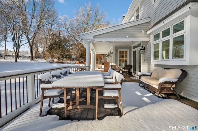 a view of a patio with table and chairs with wooden floor and fence