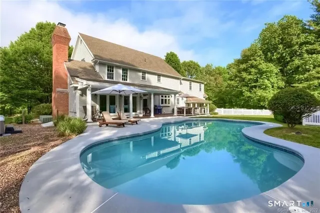 a view of a house with sitting area and swimming pool