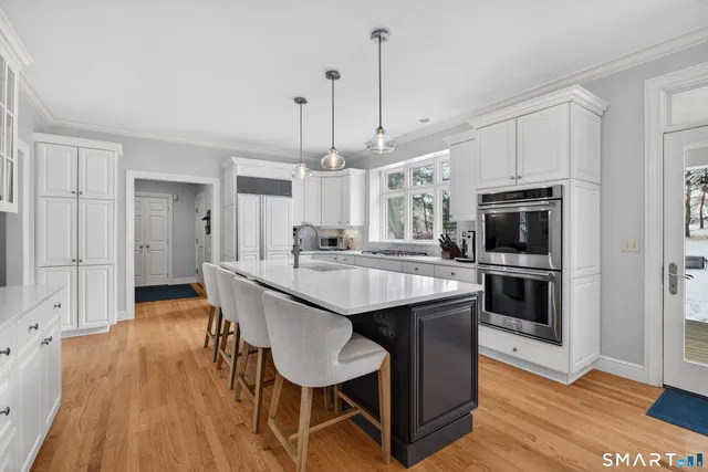 a kitchen with kitchen island granite countertop a sink a counter space appliances and cabinets