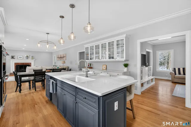 a kitchen with a sink stove and wooden floor