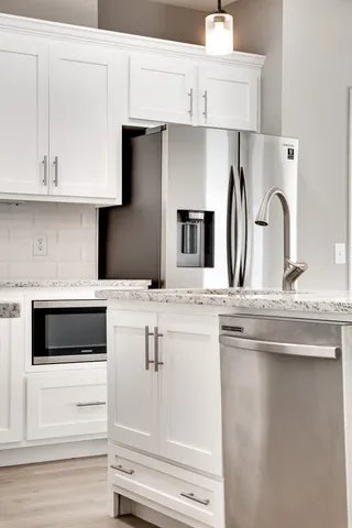 a kitchen with kitchen island stainless steel appliances and white cabinets