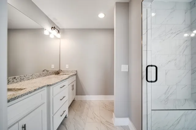 a bathroom with a granite countertop sink a shower and a mirror