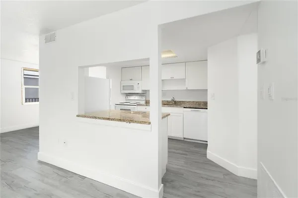 a kitchen with white cabinets and refrigerator