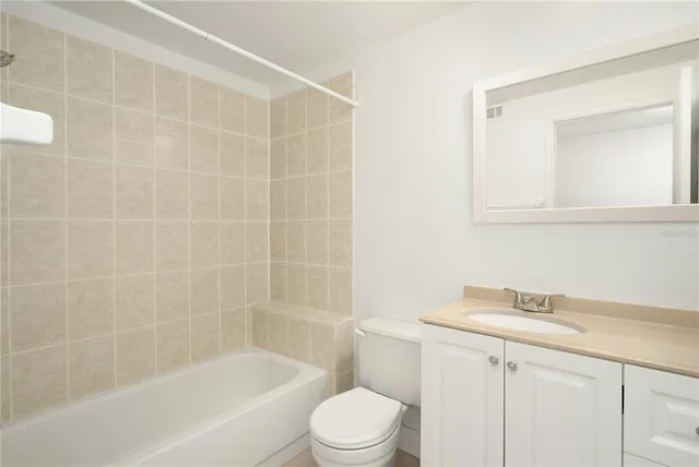 a bathroom with a bathtub shower sink vanity and toilet