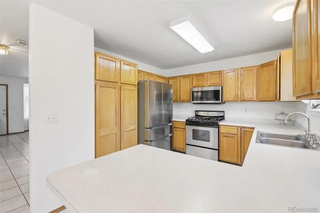 a kitchen with stainless steel appliances granite countertop a stove a sink and a refrigerator with cabinets