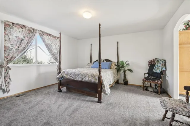 a bedroom with a bed and a large mirror