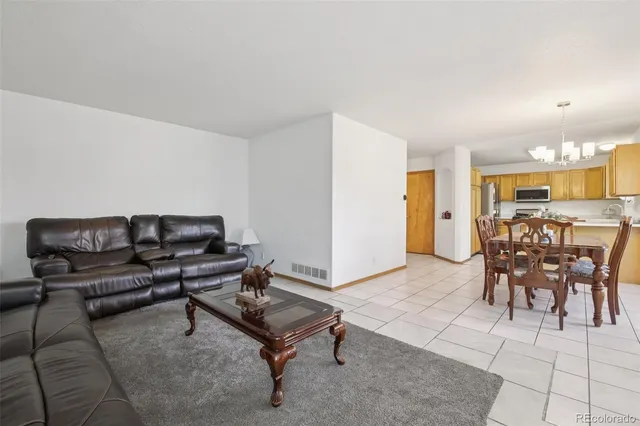 a living room with furniture a dining table and kitchen view