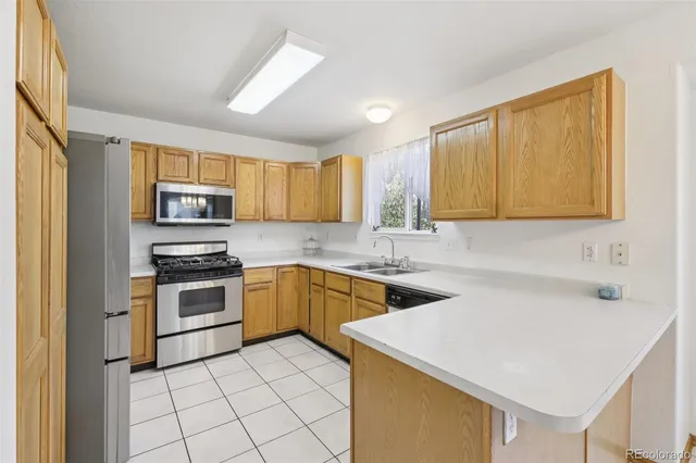 a kitchen with a sink a stove top oven and cabinetry