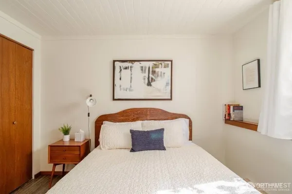 a bedroom with a large bed and a painting on the wall
