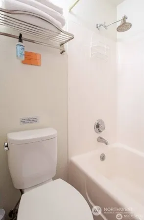 a white toilet sitting next to a bath tub