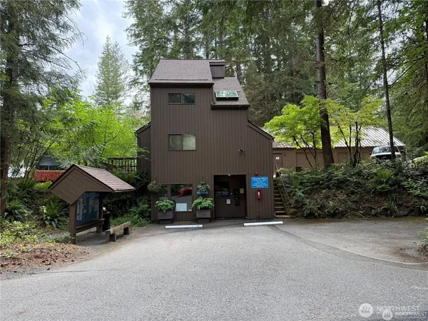 a front view of a house with a yard and tree s