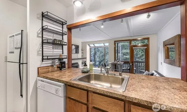 a kitchen with sink refrigerator and window
