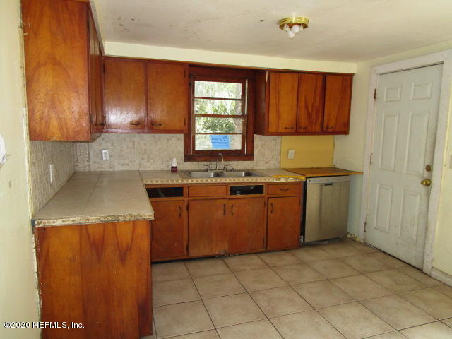 97476 Chester River Road Yulee, FL 32097 - Photo 5 of 12 a kitchen with a stove a sink a microwave and cabinets