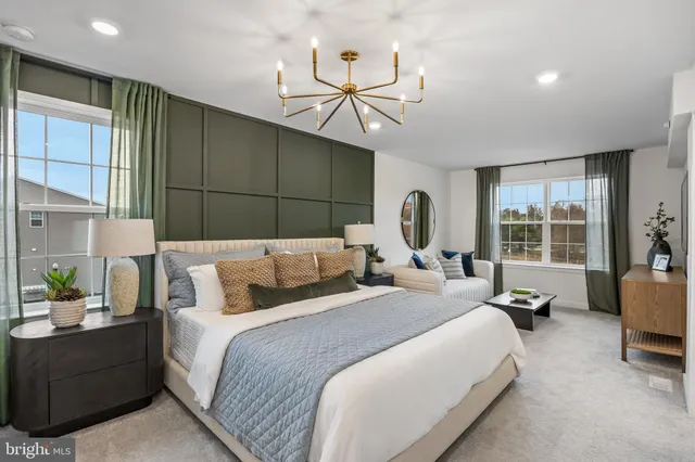 a bedroom with a bed mirror and couch