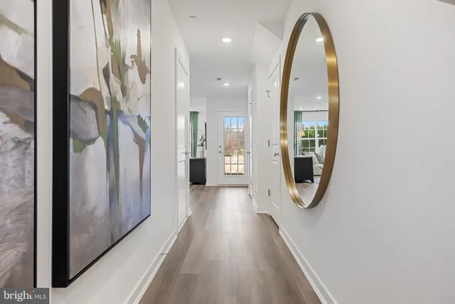 a view of a hallway with wooden floor glass door and windows