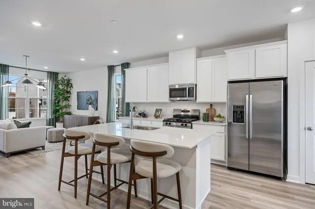 a kitchen with sink a refrigerator and chairs