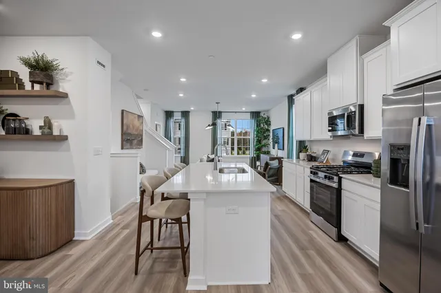 a kitchen with stainless steel appliances granite countertop a refrigerator stove microwave and cabinets