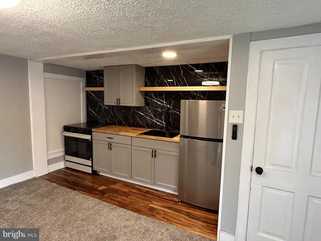 a kitchen with a refrigerator and white cabinets