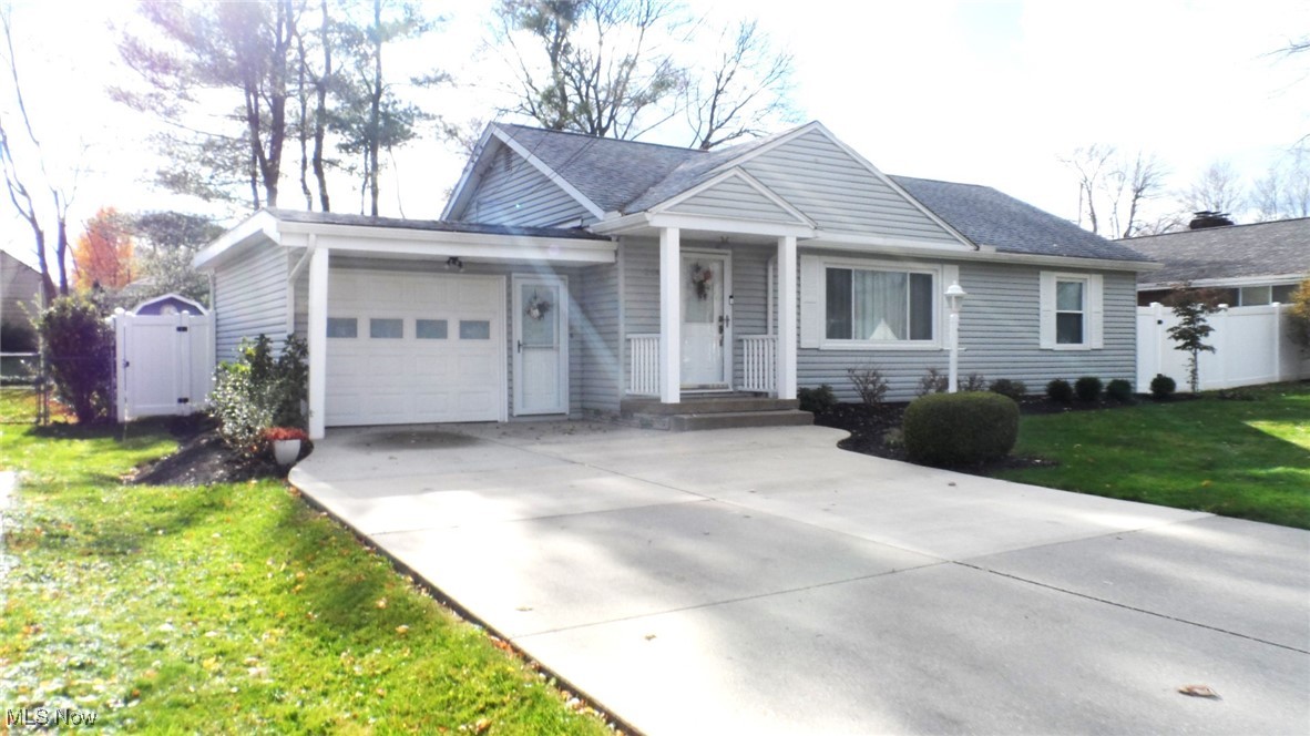 Ranch-style home featuring a garage and a front lawn