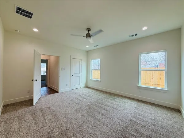 an empty room with a window and a ceiling fan