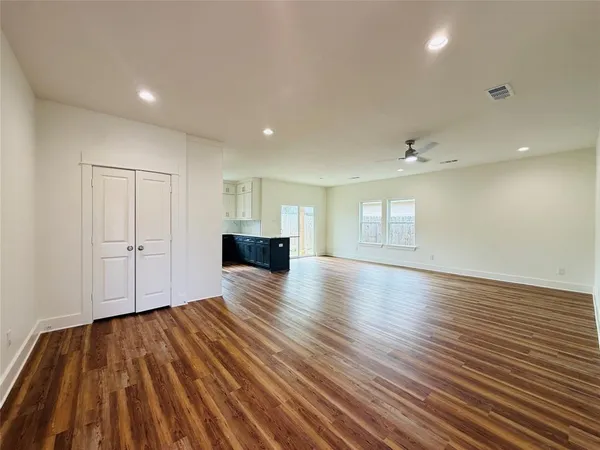 a view of empty room with wooden floor and windows