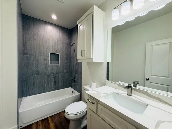 a bathroom with a sink toilet vanity and bathtub