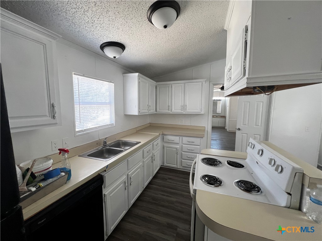 1405 Harris Hill Road, Unit 1405 San Marcos, TX 78666 - Photo 2 of 14 a kitchen with a sink a stove a microwave and cabinets