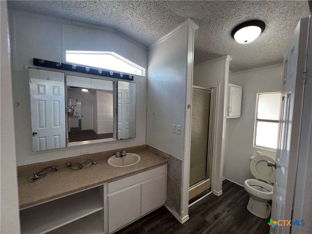 1405 Harris Hill Road, Unit 1405 San Marcos, TX 78666 - Photo 7 of 14 a bathroom with a toilet sink and mirror