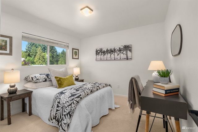 a bathroom with a granite countertop toilet sink and mirror