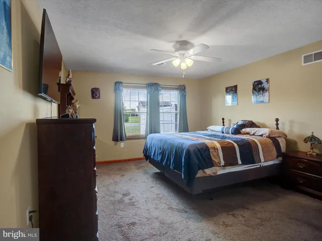 a spacious bedroom with a bed and a flat screen tv