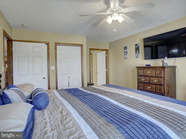 a view of a bedroom with furniture and chandelier fan