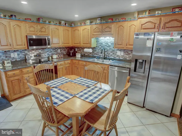 a kitchen with stainless steel appliances granite countertop a sink and a microwave