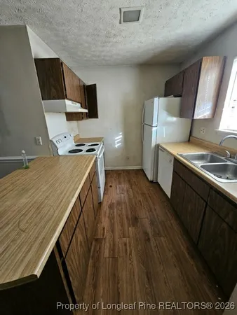 a view of a kitchen with wooden floor and electronic appliances
