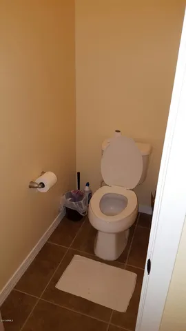 a white toilet sitting next to a white wall