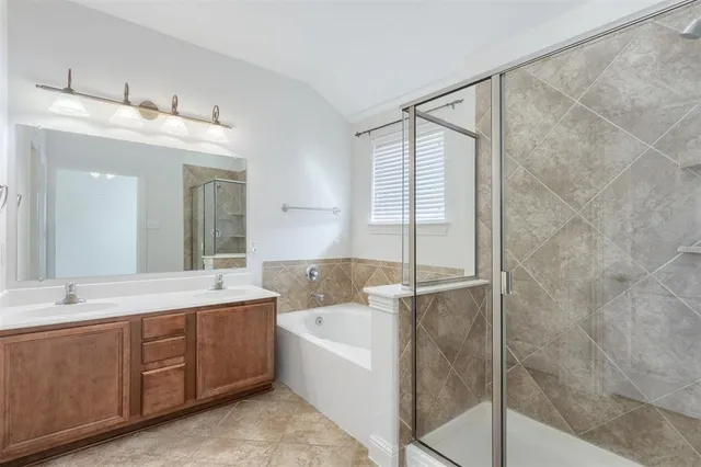 a bathroom with a double vanity sink mirror and bathtub