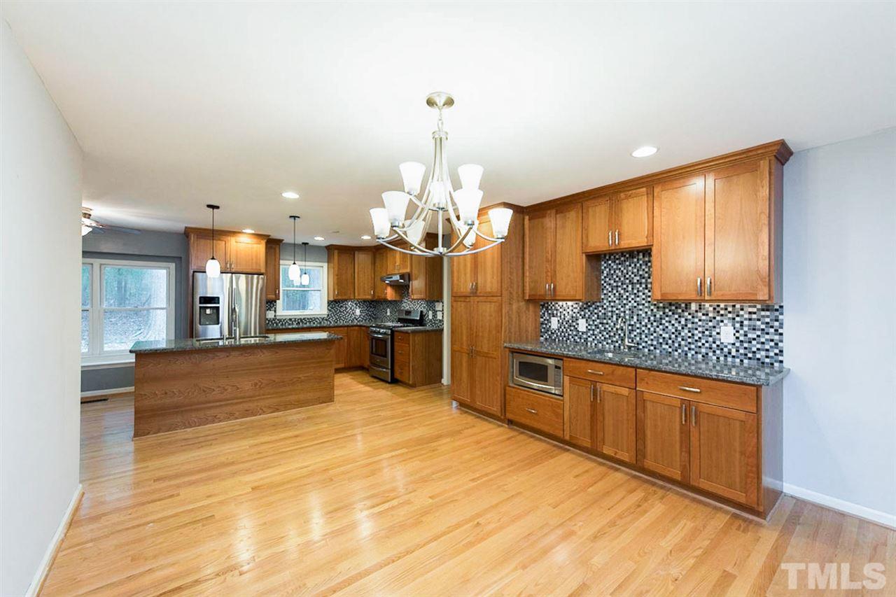 5208 Hallmark Road Durham, NC 27712 - Photo 11 of 25 a large kitchen with stainless steel appliances kitchen island granite countertop a sink and cabinets