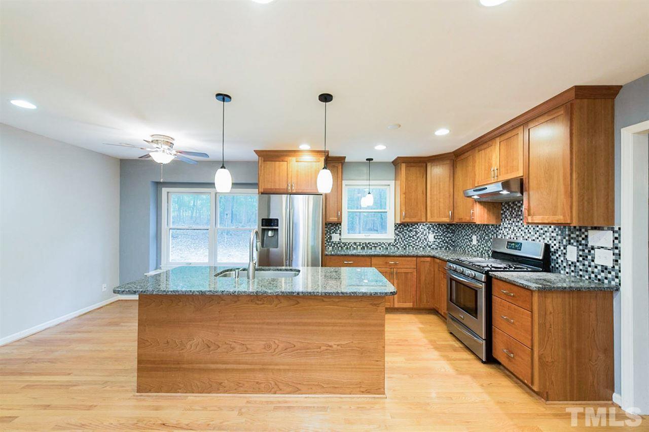 5208 Hallmark Road Durham, NC 27712 - Photo 3 of 25 a kitchen with stainless steel appliances granite countertop a sink a stove and a wooden floors