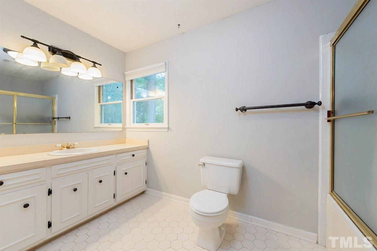 5208 Hallmark Road Durham, NC 27712 - Photo 4 of 25 a bathroom with a double vanity sink toilet mirror and bathtub