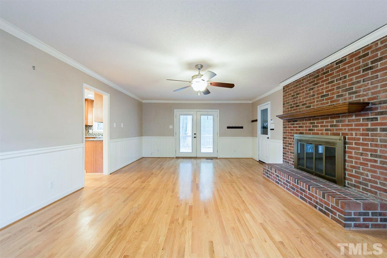 5208 Hallmark Road Durham, NC 27712 - Photo 8 of 25 a view of empty room with wooden floor and fireplace